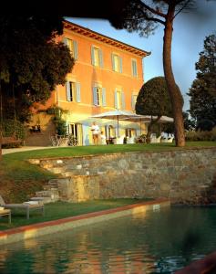 PozzoFontelunga Hotel & Villas的房屋前有游泳池的建筑