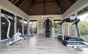纳闽巴霍Sudamala Resort, Seraya, Flores的健身房设有数台跑步机和椭圆机