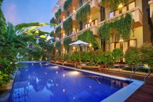 勒吉安巴厘岛勒吉安茶屋酒店的一座建筑物中央的游泳池