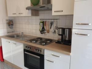 布尔格Ferienwohnung Rosi Stoppa的厨房配有白色橱柜和炉灶烤箱。