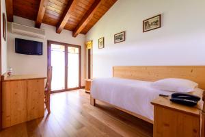 圣维托阿尔塔利亚门托诺尼斯农场酒店的一间卧室配有一张大床和电视