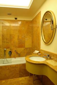 威尼斯阿尔科德伽酒店的浴室配有盥洗盆、镜子和浴缸