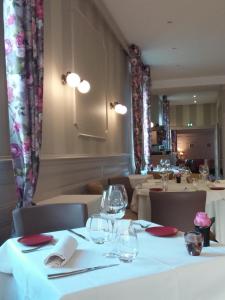 克卢尼埃洛伊丝酒店的餐厅配有白色桌椅和酒杯