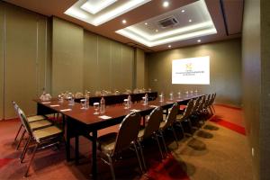 泗水格纳温萨梅尔酒店的大型会议室,配有长桌子和椅子