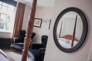 瓦伊河畔罗斯桥楼酒店的一张圆镜子,床上有床