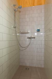 海牙VeenkadeBnB的浴室铺有白色瓷砖,设有淋浴。