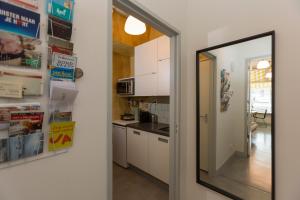 海牙VeenkadeBnB的厨房配有白色橱柜和镜子