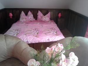 鲁哈科维斯维拉帕特里斯旅馆的一间卧室配有粉红色的床铺,提供粉红色的床单和鲜花