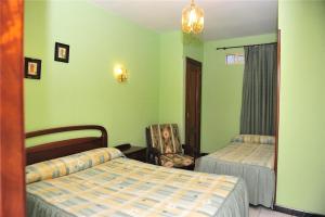 巴绍里阿丽兹旅馆的一间卧室配有两张床和椅子