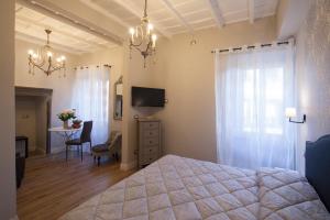 维泰博La Rocca Suite的一间卧室配有一张床、一张桌子和一台电视