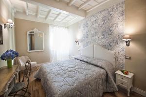 维泰博La Rocca Suite的一间卧室配有一张床、一张桌子和一面镜子