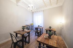 维泰博La Rocca Suite的用餐室配有木桌、椅子和吊灯。