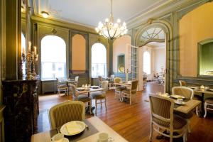 根特汉斯劳特查姆酒店的餐厅设有桌椅和窗户。