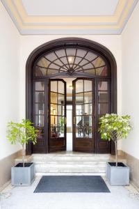 根特汉斯劳特查姆酒店的前方有两棵盆栽树的敞门