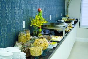 XanxerêSeville Park Hotel的包括食物、罐子和鲜花的自助餐