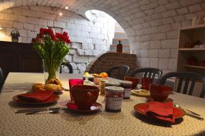 Saint-Pol-sur-Ternoise拉法姆杜博基努阿酒店的桌子上带盘子和杯子,带食物