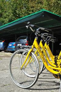 佩萨罗可利佩酒店的两辆黄色自行车停在停车场