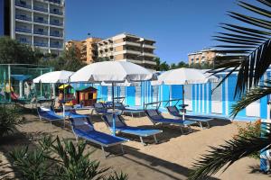 佩萨罗可利佩酒店的一组椅子和遮阳伞,位于游泳池旁