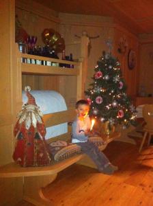 福尔加里亚瑞莱斯费奥迪博斯科酒店的坐在圣诞树旁长凳上的小孩