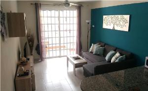厄尔梅达诺Almi Cabezo appartamento con terrazza El Médano的带沙发和蓝色墙壁的客厅