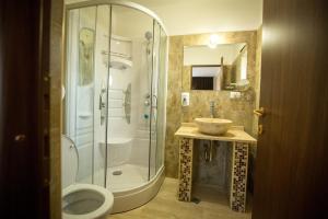 克拉约瓦MBI Travel Inn的带淋浴、卫生间和盥洗盆的浴室