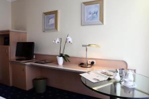 慕尼黑安比恩特甘尼酒店的酒店客房设有一张桌子、一台电视和一张桌子