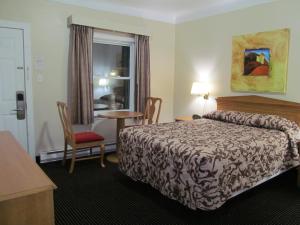 伦敦安大略省伦敦旅馆的酒店客房设有床、桌子和窗户。