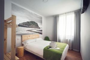 毕尔巴鄂瑟兰特斯休闲旅馆的一间卧室配有一张壁画床