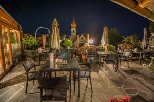 索普拉布扎诺德瑞比尔肯酒店的一间晚上配有桌椅和遮阳伞的餐厅