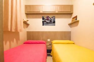扎马亚Camping & Bungalows Zumaia的客房设有两张床和一张书桌