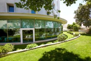 法蒂玛圣玛丽亚酒店的草坪上设有玻璃窗户的大型建筑
