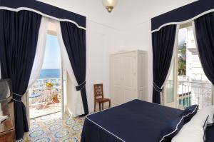 阿马尔菲公馆酒店的一间卧室配有一张床,享有海景