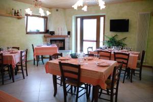 卡普雷塞·米开朗基罗卡西纳农家乐的一间带桌椅和电视的用餐室