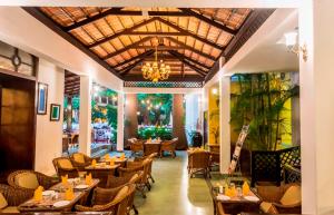 迈索尔Royal Orchid Metropole Mysore的一间带桌椅和吊灯的餐厅