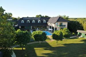TauerChristinenhof & Spa - Wellnesshotel am Rande des Spreewalds的享有带游泳池的房屋的空中景致