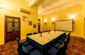 迈索尔Royal Orchid Metropole Mysore的一间会议室,内设一张大桌子和一个白板