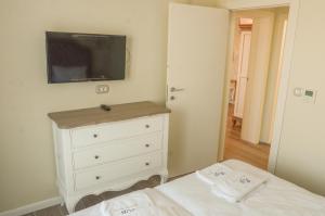斯维伦格勒Residence Bilyana的一间卧室配有梳妆台和墙上的电视