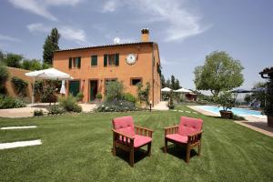 蒙特罗伯托Poggio Montali的一座带两把椅子的房子和一座庭院内的游泳池