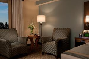 达拉姆达勒姆千禧国际酒店的酒店客房带两把椅子、一张桌子和一张床