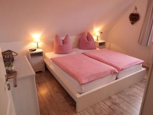 霍瓦赫特Kranichnest的一间卧室配有一张带粉色床单和枕头的床。