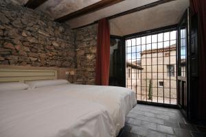 阿尔巴拉辛La Casa Grande de Albarracín的一间卧室设有一张大床和一个大窗户