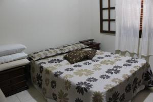 阿拉亚尔-杜卡布阿拉亚尔多卡博阁楼公寓的一间卧室配有一张带花卉图案的毯子的床