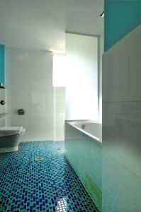 圣尼古拉奥斯Krotiri Resort的浴室铺有蓝色瓷砖地板,配有浴缸。