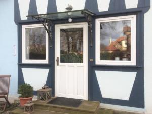 WolkramshausenPension Elise的蓝色的房子,有白色的门和窗户