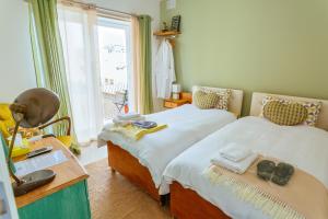 梅利哈Ghand in-Nanna B&B的一间卧室设有两张床、一张桌子和一个窗口。