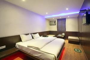 瓦拉纳西Hotel Varanasi Palace的一间带大床和电视的卧室