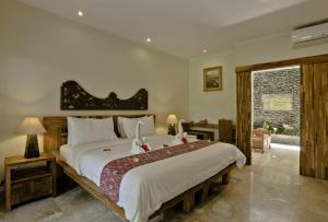 乌布Sri Ratih Cottages, CHSE Certified的一间卧室,卧室内配有一张大床