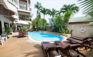 芭东海滩棕榈景度假酒店的一个带桌椅的度假村游泳池