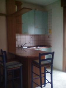 格拉多Appartamento Perco Riva Slataper的厨房配有带2把椅子和水槽的台面
