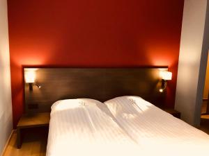 迪斯特德珐昂斯克朗酒店的卧室配有白色的床铺和红色的墙壁